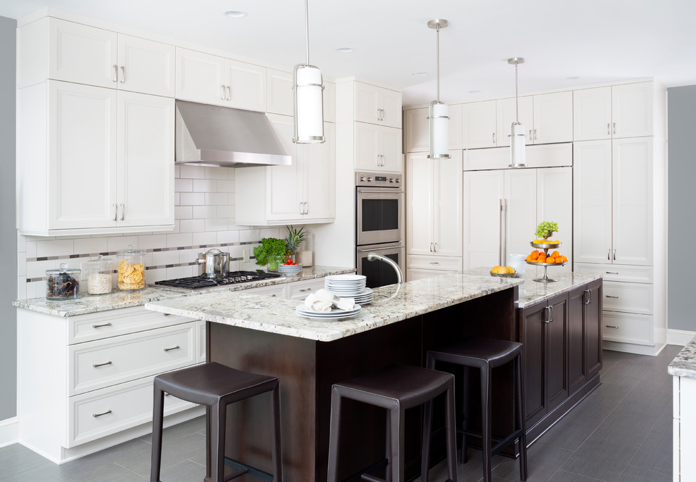 Example of a large transitional u-shaped porcelain tile enclosed kitchen design in Baltimore with recessed-panel cabinets, white cabinets, white backsplash, subway tile backsplash, stainless steel appliances, an island, a single-bowl sink and quartz countertops