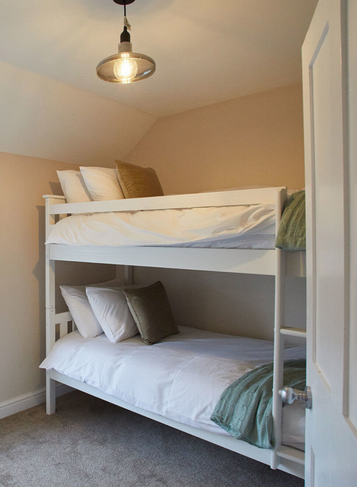 This is an example of a medium sized classic guest bedroom in London with beige walls, carpet and beige floors.