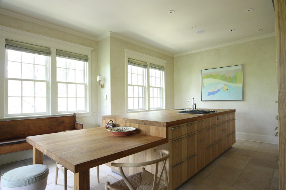 This is an example of a country eat-in kitchen in Atlanta with flat-panel cabinets, medium wood cabinets and wood benchtops.