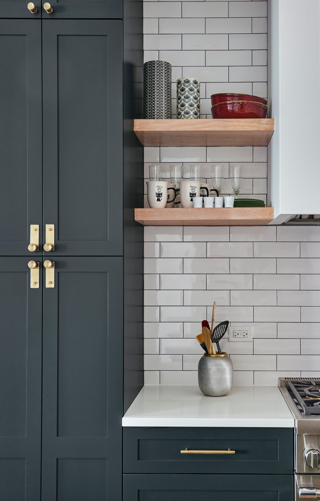 Design ideas for a mid-sized contemporary open plan kitchen in Chicago with subway tile splashback, medium hardwood floors, with island, white benchtop, a drop-in sink, wood benchtops, black appliances, white splashback and black cabinets.
