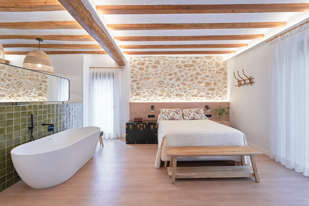 Cette image montre une chambre parentale beige et blanche rustique de taille moyenne avec un mur blanc, parquet clair, un sol beige et un plafond voûté.