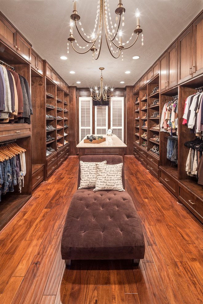 Design ideas for a large traditional gender-neutral dressing room in Houston with recessed-panel cabinets, dark wood cabinets and medium hardwood floors.