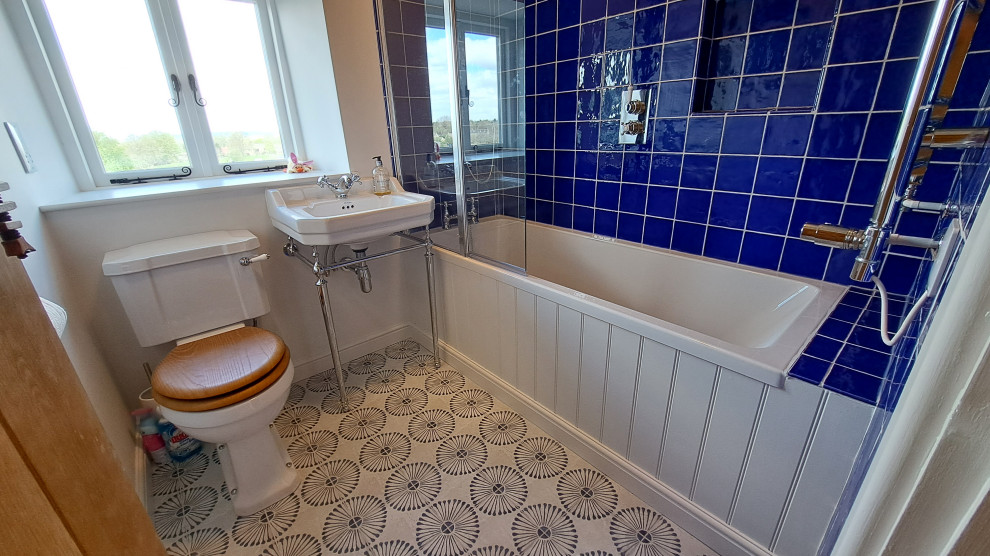 На фото: маленькая ванная комната в классическом стиле с накладной ванной, душем над ванной, раздельным унитазом, синей плиткой, керамической плиткой, полом из керамогранита, синим полом, тумбой под одну раковину и напольной тумбой для на участке и в саду с