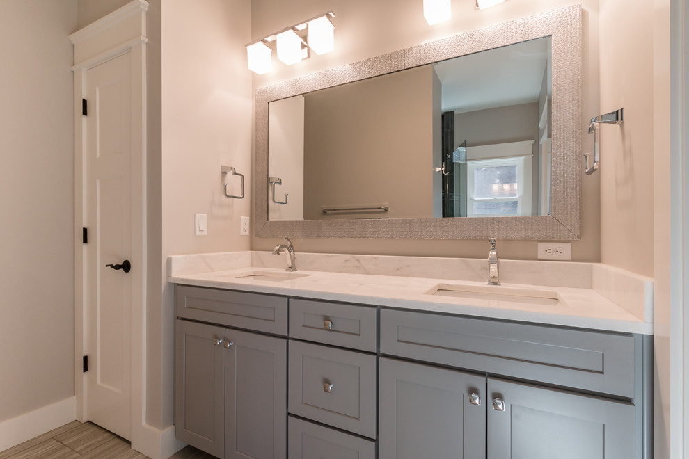 Mid-sized arts and crafts 3/4 bathroom in Other with raised-panel cabinets, grey cabinets, a corner tub, a corner shower, a one-piece toilet, white tile, stone slab, beige walls, dark hardwood floors, a drop-in sink and solid surface benchtops.
