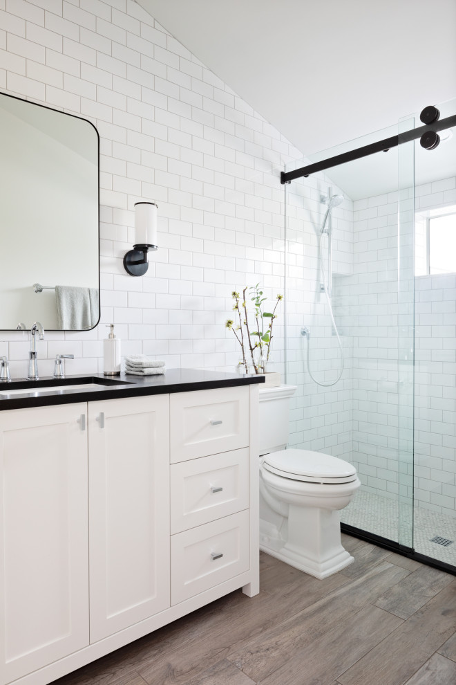 Design ideas for a small nautical shower room bathroom in Tampa with recessed-panel cabinets, medium wood cabinets, a built-in bath, white walls, medium hardwood flooring, a built-in sink, brown floors, black worktops, a shower bench, a single sink and a built in vanity unit.