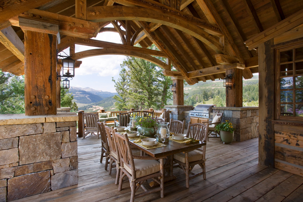Mountain style balcony deck photo with a roof extension