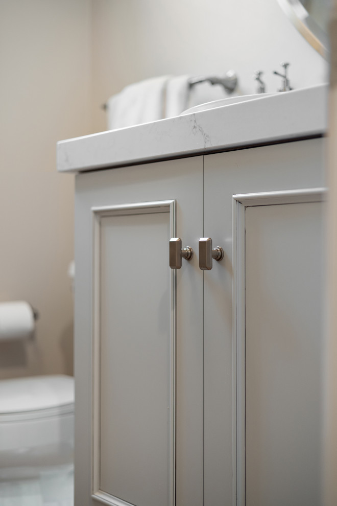 Cette photo montre un petit WC et toilettes chic avec un placard à porte shaker, des portes de placard beiges, WC séparés, un mur blanc, un sol en bois brun, une vasque, un plan de toilette en quartz modifié, un sol marron, un plan de toilette blanc et meuble-lavabo sur pied.