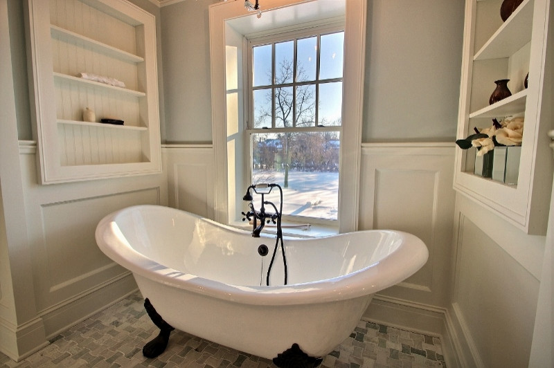 Photo of a large traditional master bathroom in Cleveland with furniture-like cabinets, dark wood cabinets, a claw-foot tub, an alcove shower, a two-piece toilet, white tile, marble, green walls, marble floors, an undermount sink, marble benchtops, multi-coloured floor, a hinged shower door, multi-coloured benchtops, an enclosed toilet, a double vanity, a freestanding vanity and decorative wall panelling.