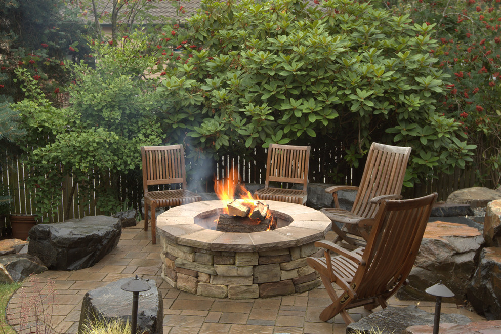 Photo of a large traditional backyard patio in Seattle with a fire feature, natural stone pavers and no cover.