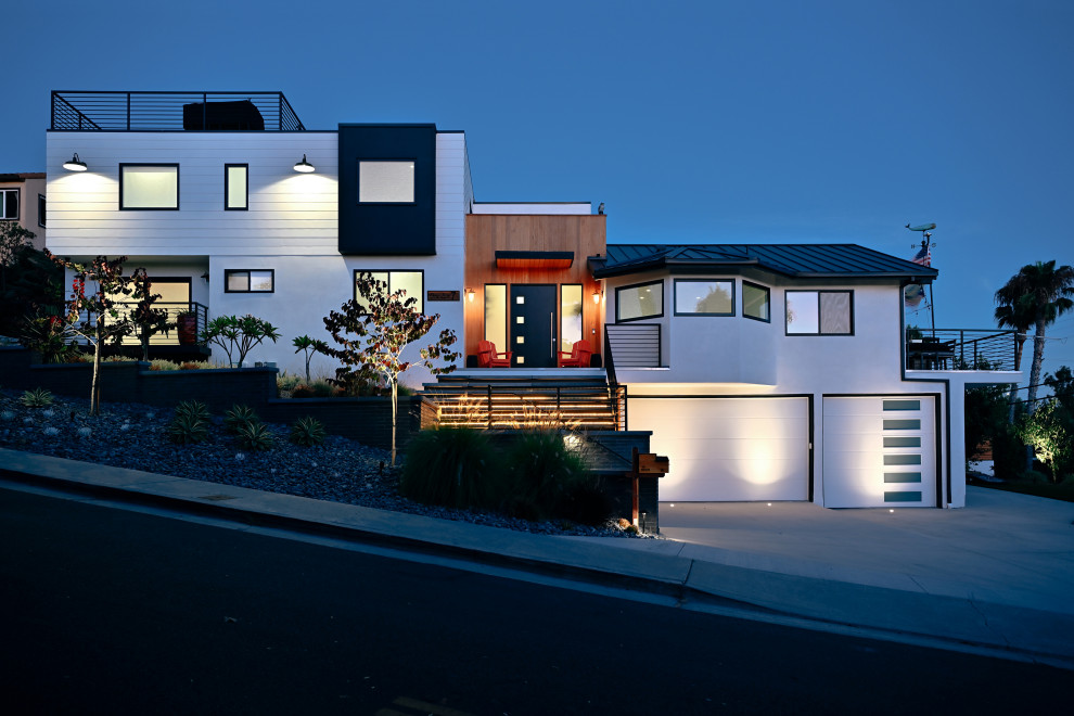 Immagine della facciata di una casa bianca stile marinaro a piani sfalsati di medie dimensioni con rivestimenti misti, copertura in metallo o lamiera e tetto nero