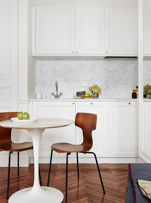 This is an example of a small transitional single-wall open plan kitchen in Paris with an undermount sink, white cabinets, marble benchtops, white splashback, stone slab splashback and medium hardwood floors.