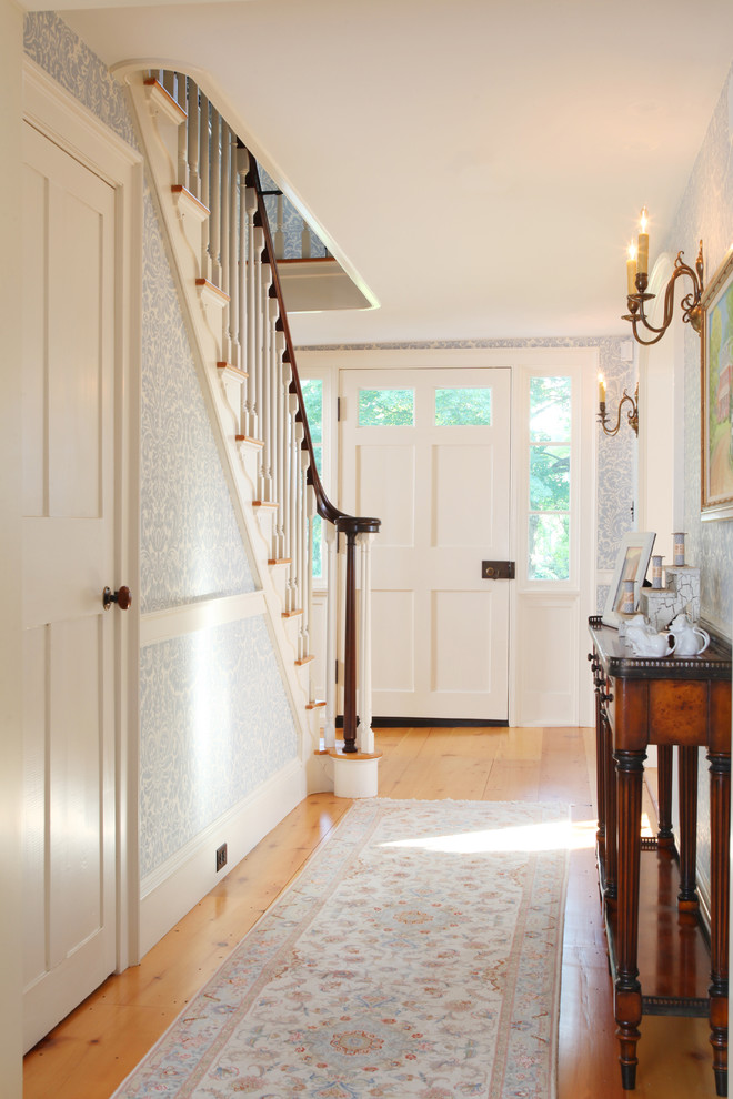 Photo of a mid-sized traditional entry hall in Boston with a single front door, a white front door, medium hardwood floors, multi-coloured walls and beige floor.