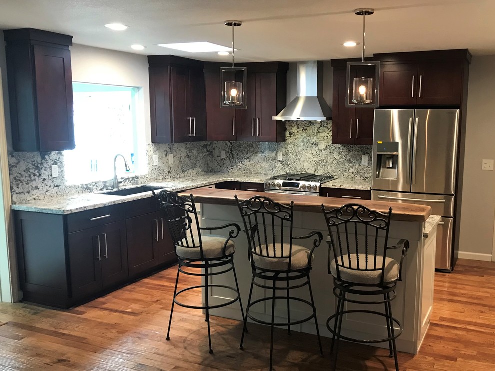 Inspiration for a mid-sized transitional l-shaped light wood floor and brown floor eat-in kitchen remodel with an undermount sink, shaker cabinets, dark wood cabinets, granite countertops, multicolored backsplash, stone slab backsplash, stainless steel appliances, an island and multicolored countertops