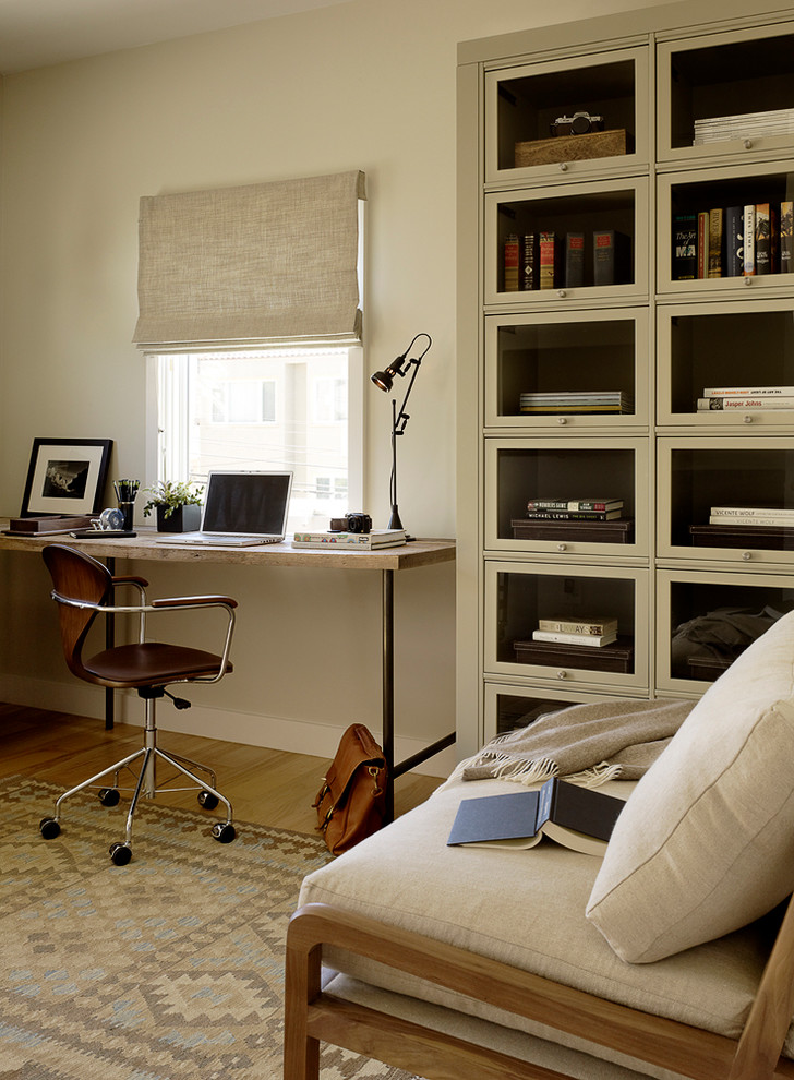 Contemporary home office in San Francisco with white walls, medium hardwood floors and a freestanding desk.