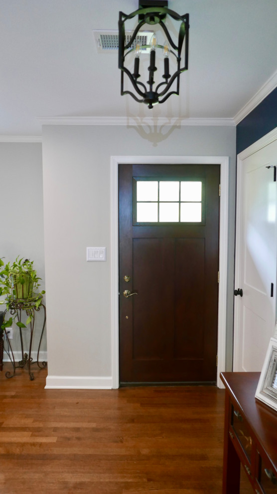 Foyer - mid-sized transitional medium tone wood floor and brown floor foyer idea with gray walls and a dark wood front door