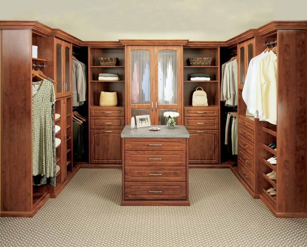 Design ideas for a mid-sized gender-neutral walk-in wardrobe in Orange County with raised-panel cabinets and medium wood cabinets.