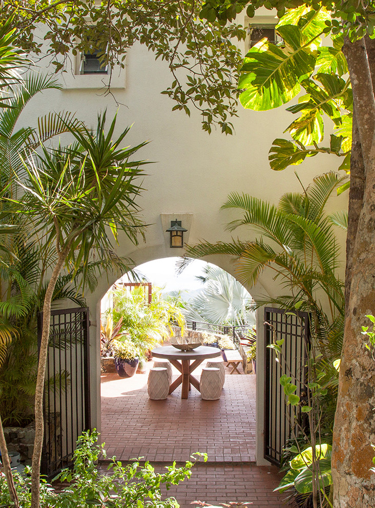 Inspiration for a tropical patio in Other with brick pavers.