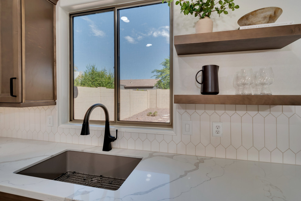 Inspiration for a mid-sized transitional u-shaped ceramic tile and brown floor eat-in kitchen remodel in Phoenix with beaded inset cabinets, brown cabinets, quartzite countertops, white backsplash, ceramic backsplash, an island and white countertops