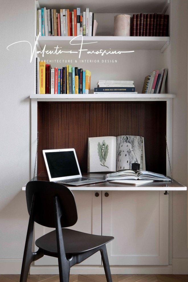 Small modern home office in Turin with a library, white walls, light hardwood floors, a freestanding desk and coffered.
