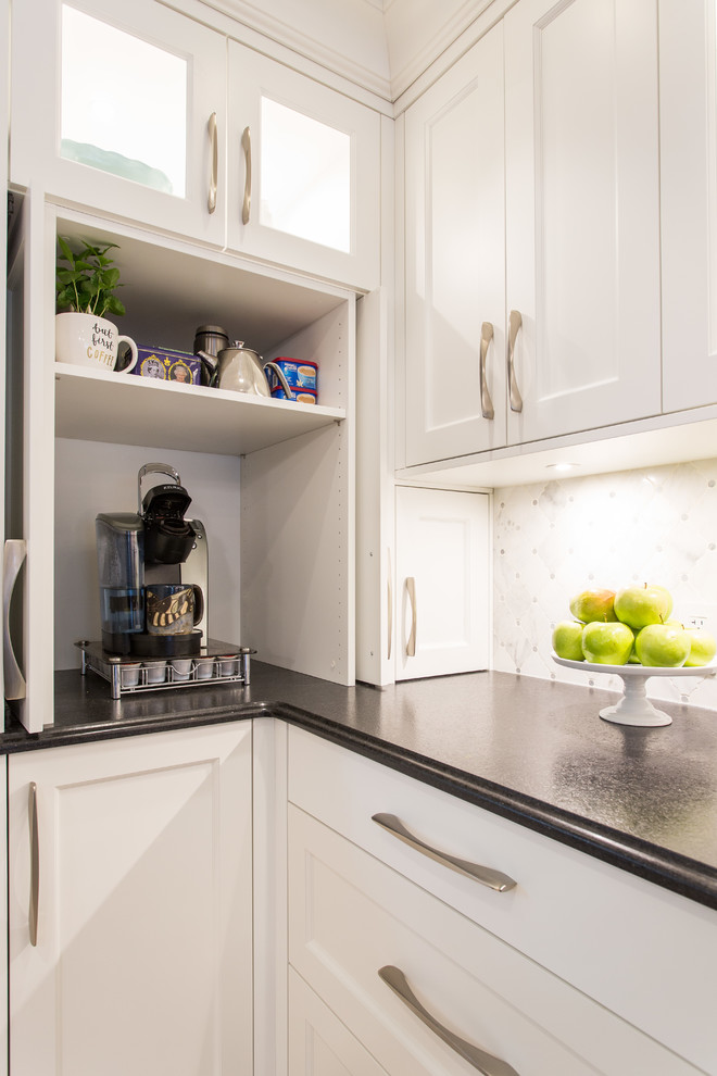 Eat-in kitchen - large transitional l-shaped medium tone wood floor and beige floor eat-in kitchen idea in Vancouver with an undermount sink, shaker cabinets, white cabinets, granite countertops, gray backsplash, marble backsplash, stainless steel appliances, an island and black countertops
