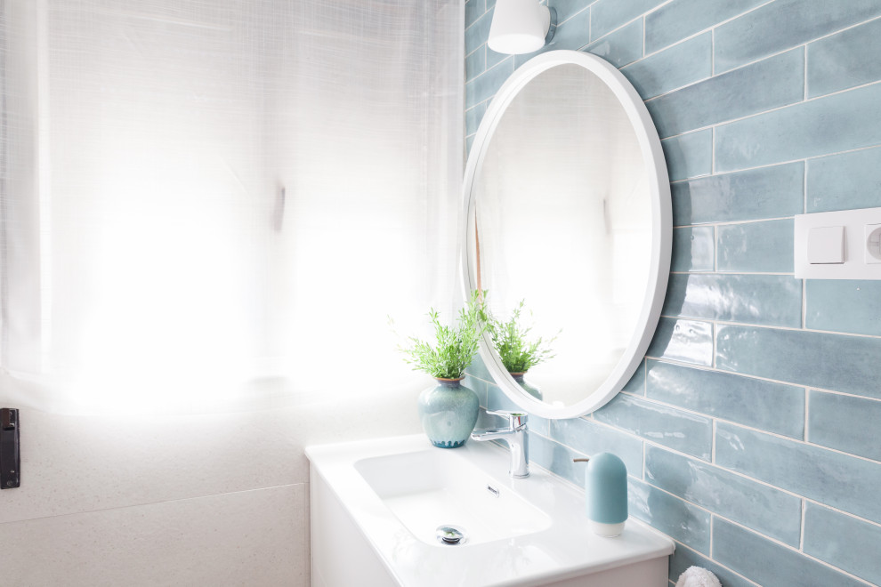 На фото: маленькая ванная комната в современном стиле с белыми фасадами, угловым душем, унитазом-моноблоком, синей плиткой, керамической плиткой, белыми стенами, полом из керамогранита, душевой кабиной, накладной раковиной, столешницей из плитки, коричневым полом, душем с раздвижными дверями, белой столешницей, окном, тумбой под одну раковину и подвесной тумбой для на участке и в саду с