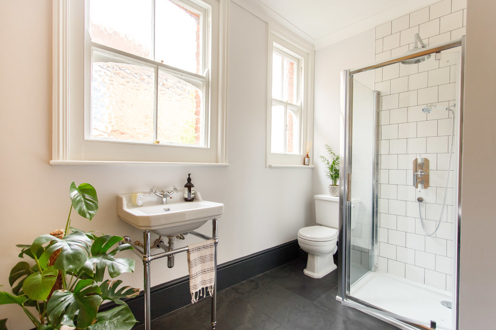 Inspiration for a mid-sized transitional kids bathroom in Kent with medium wood cabinets, a claw-foot tub, white tile, ceramic tile, slate floors and black floor.