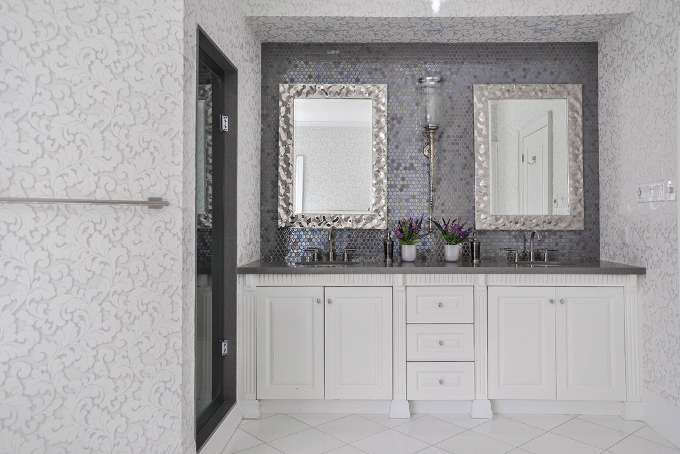 Photo of a transitional master bathroom in Toronto with raised-panel cabinets, white cabinets, gray tile, grey walls, an undermount sink, a hinged shower door and grey benchtops.