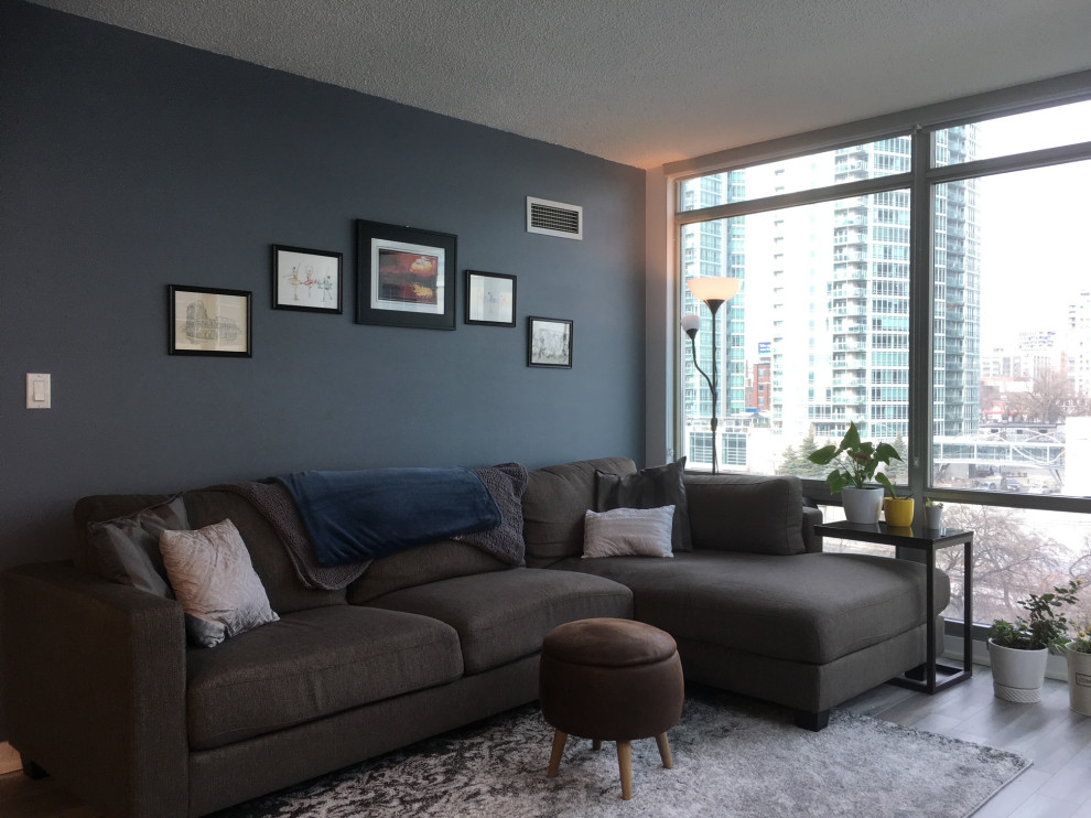 This is an example of a small modern open concept living room in Toronto with light hardwood floors and grey floor.