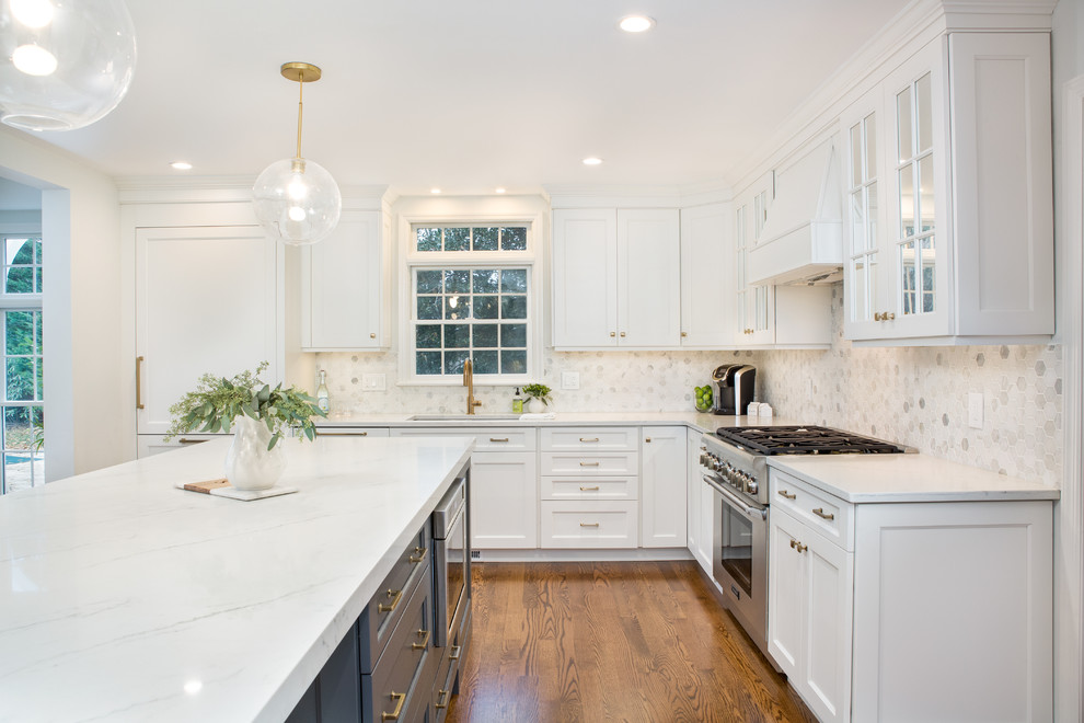 Design ideas for a large transitional open plan kitchen in New York with an undermount sink, flat-panel cabinets, white cabinets, quartz benchtops, white splashback, marble splashback, stainless steel appliances, medium hardwood floors, with island, brown floor and white benchtop.
