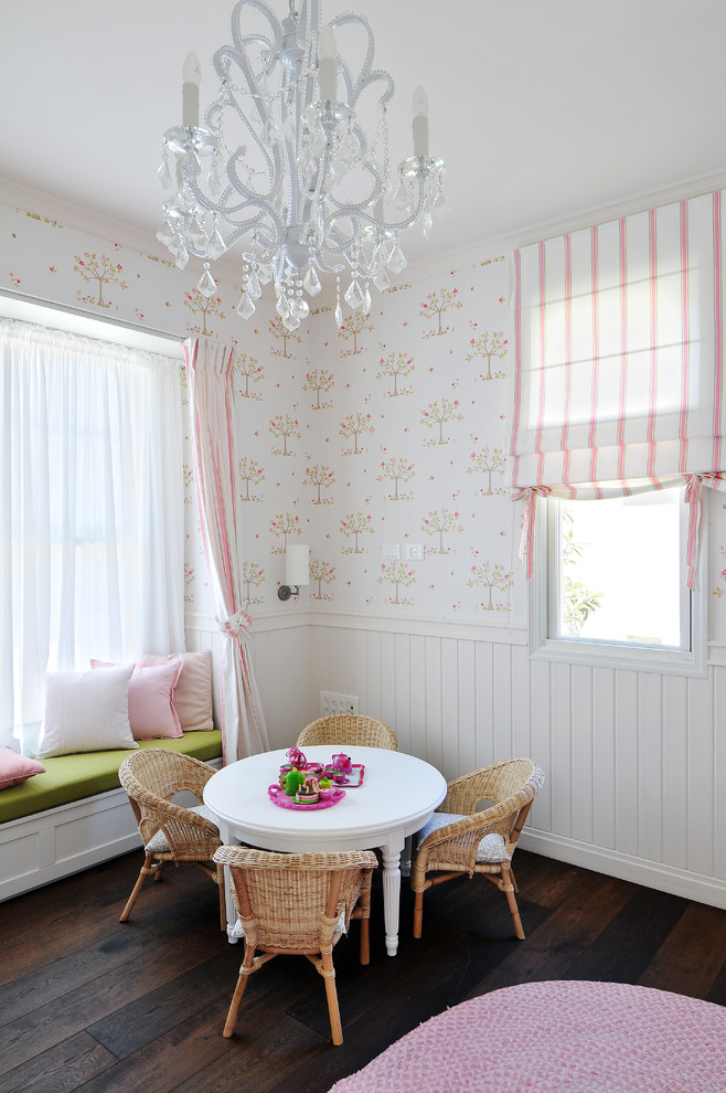 Photo of a traditional kids' room for girls in Other with white walls and dark hardwood floors.