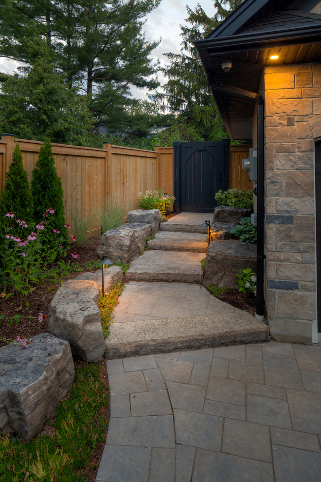 Design ideas for a large contemporary side yard partial sun garden in Toronto with a garden path and concrete pavers.