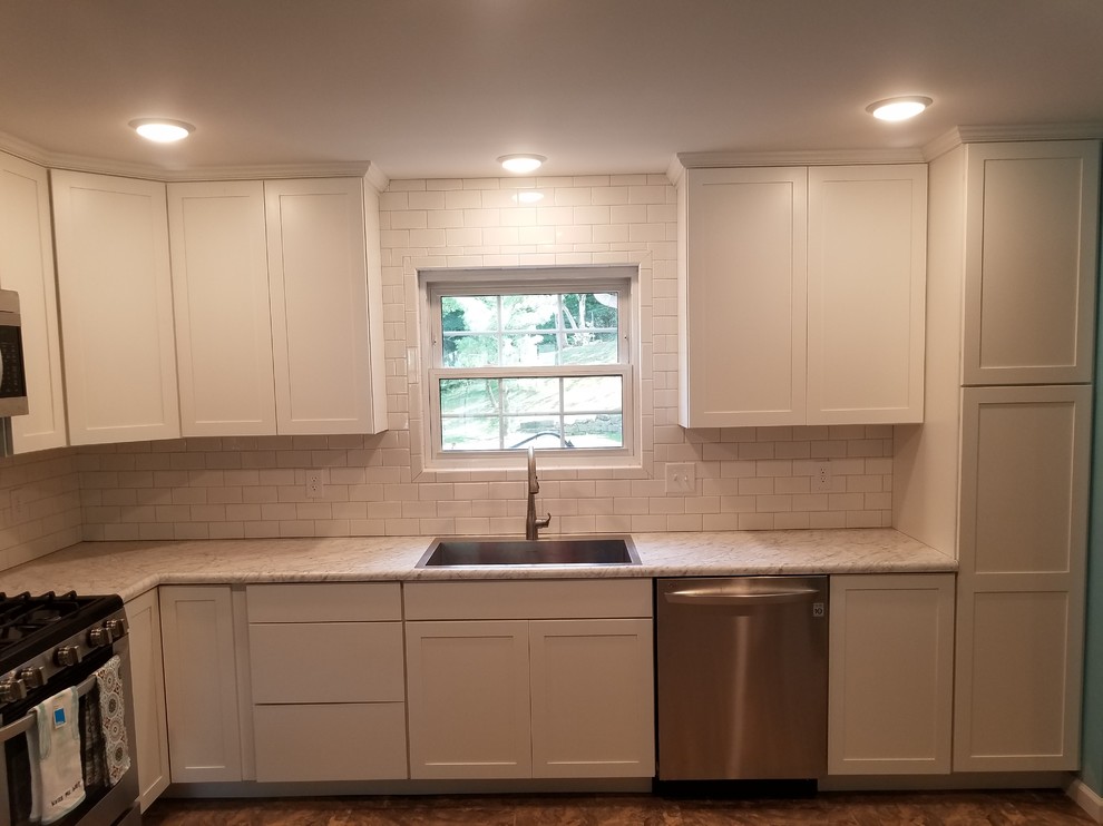 Example of a mid-sized transitional l-shaped vinyl floor and beige floor eat-in kitchen design in Cincinnati with a single-bowl sink, shaker cabinets, white cabinets, laminate countertops, white backsplash, porcelain backsplash, stainless steel appliances and no island