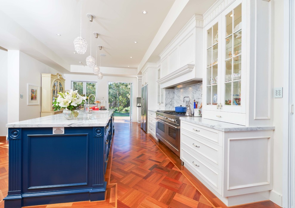 Traditional galley kitchen in Brisbane with glass-front cabinets, blue cabinets, white splashback, stone slab splashback and stainless steel appliances.