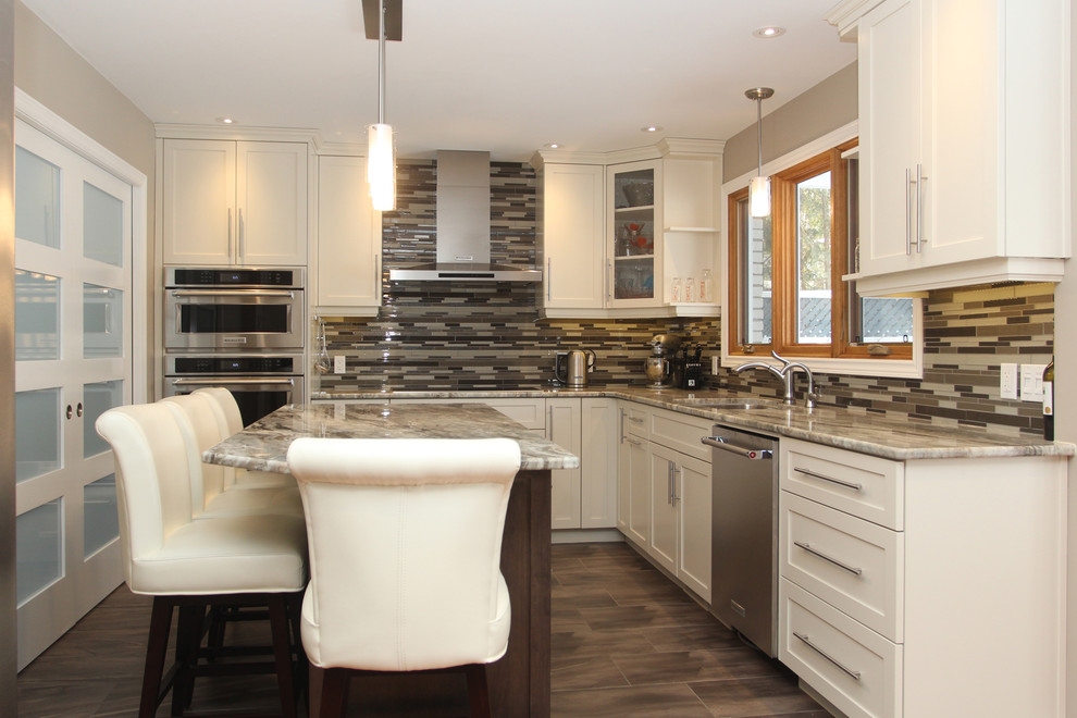 Eat-in kitchen - mid-sized transitional l-shaped dark wood floor and brown floor eat-in kitchen idea with an undermount sink, white cabinets, granite countertops, multicolored backsplash, glass tile backsplash, stainless steel appliances, an island and shaker cabinets