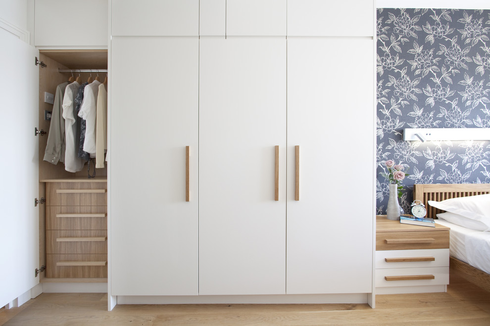 Photo of a contemporary built-in wardrobe in London with white cabinets.