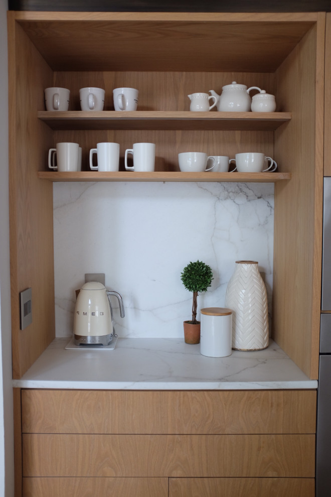 Imagen de cocina blanca y madera actual grande con armarios con paneles lisos, puertas de armario de madera clara, encimera de mármol, salpicadero blanco, salpicadero de mármol, suelo de madera clara y barras de cocina