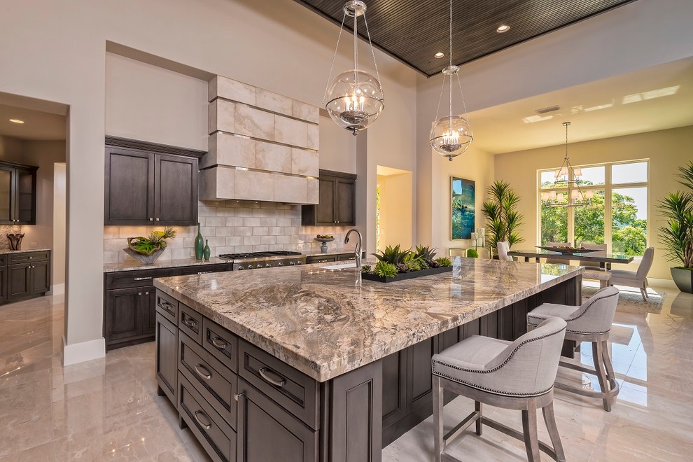 Inspiration for a large transitional open plan kitchen in Austin with an undermount sink, dark wood cabinets, beige splashback, stainless steel appliances, with island, granite benchtops, subway tile splashback, marble floors, beige floor and recessed-panel cabinets.