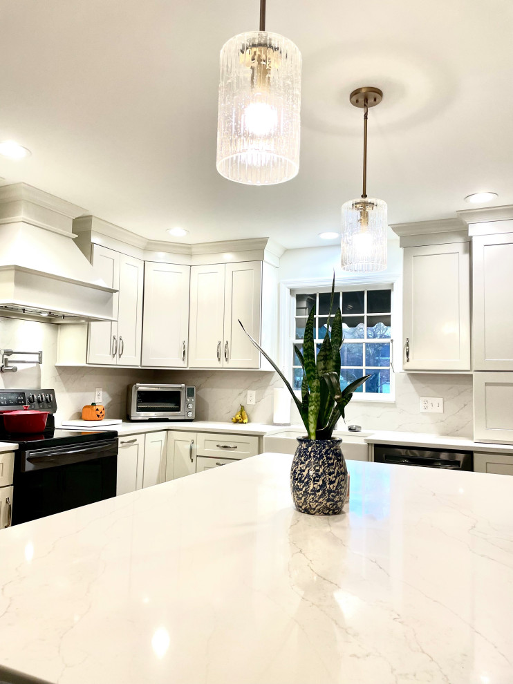 Example of a transitional l-shaped light wood floor and beige floor eat-in kitchen design with a farmhouse sink, shaker cabinets, white cabinets, quartz countertops, white backsplash, quartz backsplash, black appliances, an island and white countertops