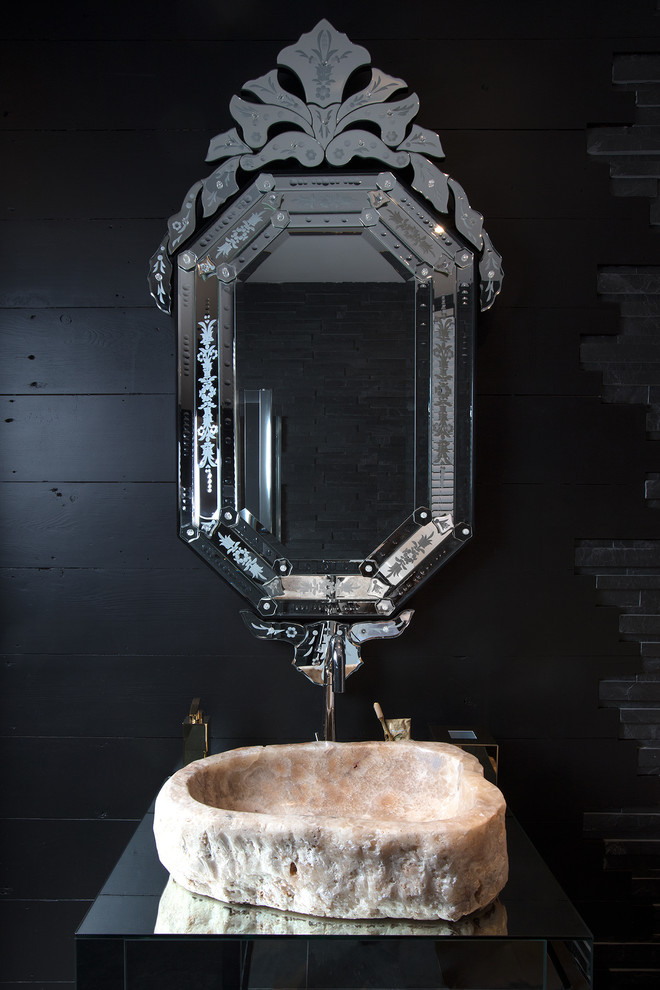 Inspiration for an eclectic powder room in London with black walls and a vessel sink.