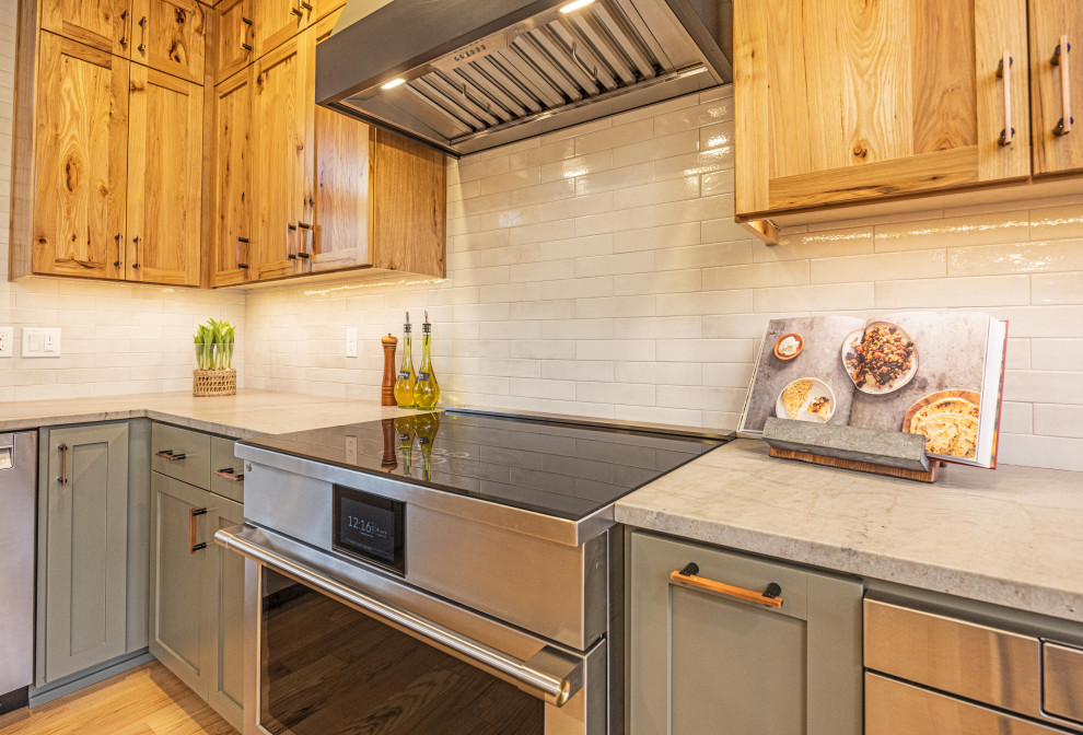 Large mountain style u-shaped light wood floor and brown floor eat-in kitchen photo with a farmhouse sink, shaker cabinets, quartzite countertops, gray backsplash, ceramic backsplash, stainless steel appliances, a peninsula and gray countertops