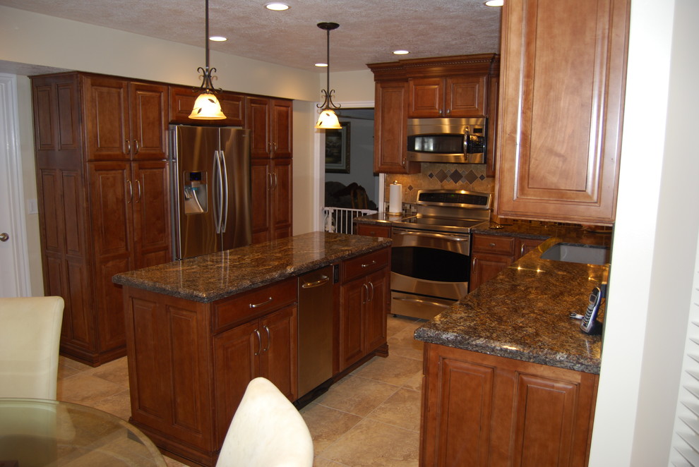 Mid-sized traditional l-shaped eat-in kitchen in Other with a drop-in sink, raised-panel cabinets, dark wood cabinets, granite benchtops, stainless steel appliances, with island, porcelain floors and beige floor.