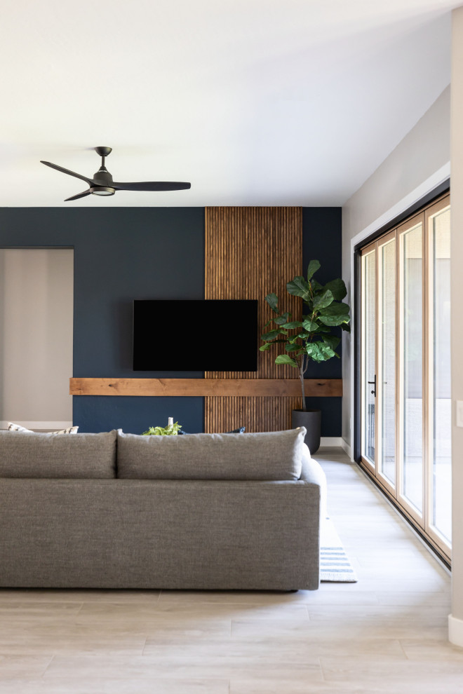 Réalisation d'un salon minimaliste en bois de taille moyenne avec un mur bleu, parquet clair, aucune cheminée, un téléviseur fixé au mur et un sol beige.