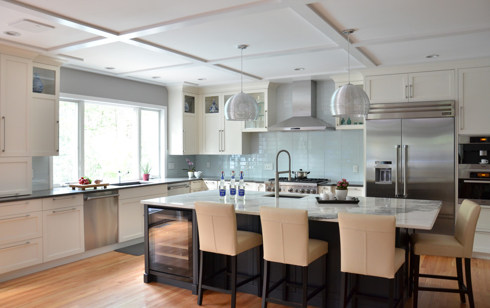 Design ideas for a contemporary kitchen in Boston with recessed-panel cabinets, blue splashback, glass tile splashback, stainless steel appliances, light hardwood floors and with island.