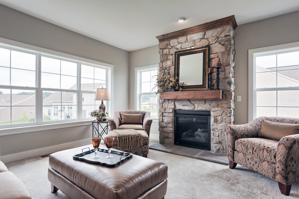 This is an example of a large traditional enclosed family room in Other with beige walls, carpet, a standard fireplace and a stone fireplace surround.