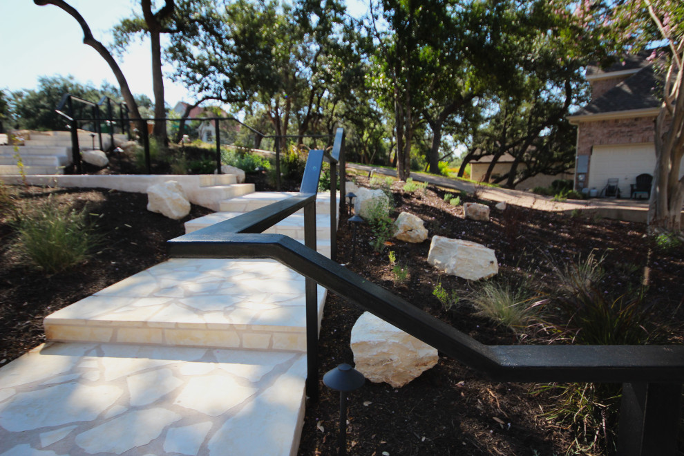Design ideas for an expansive contemporary front yard xeriscape in Austin with a metal fence, with path and mulch.