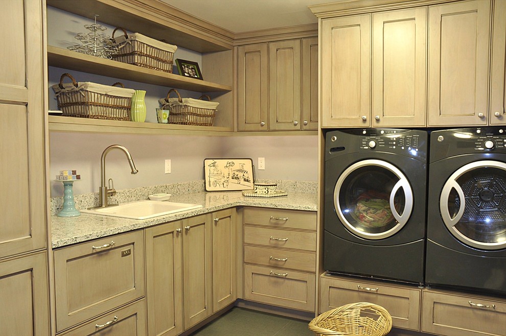Photo of a contemporary l-shaped utility room in Seattle with recessed-panel cabinets, recycled glass benchtops, a side-by-side washer and dryer, a drop-in sink and ceramic floors.