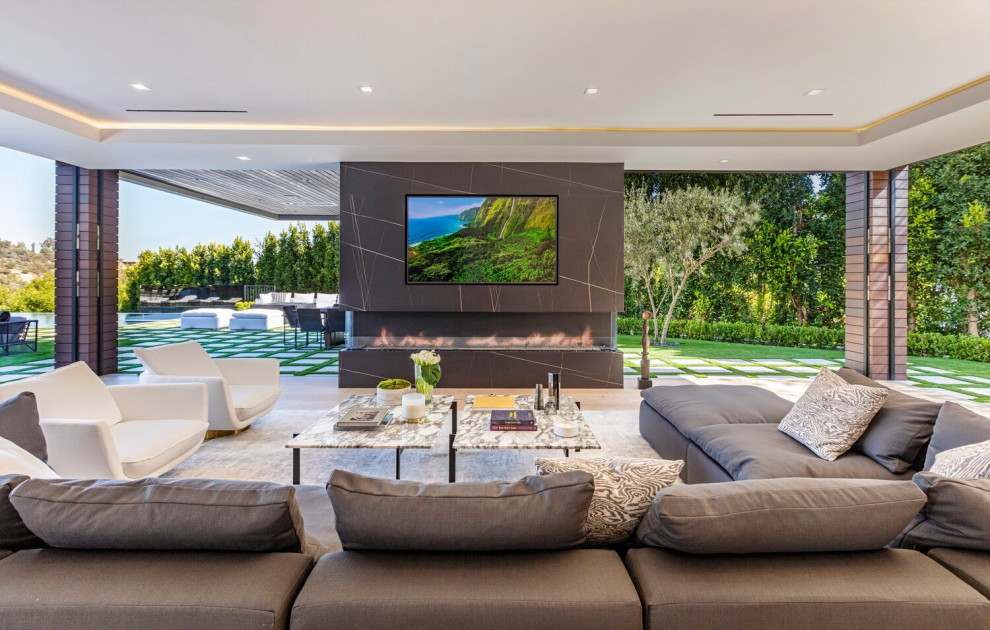 Living room - huge modern open concept beige floor and tray ceiling living room idea in Los Angeles with a standard fireplace, a stone fireplace and a wall-mounted tv