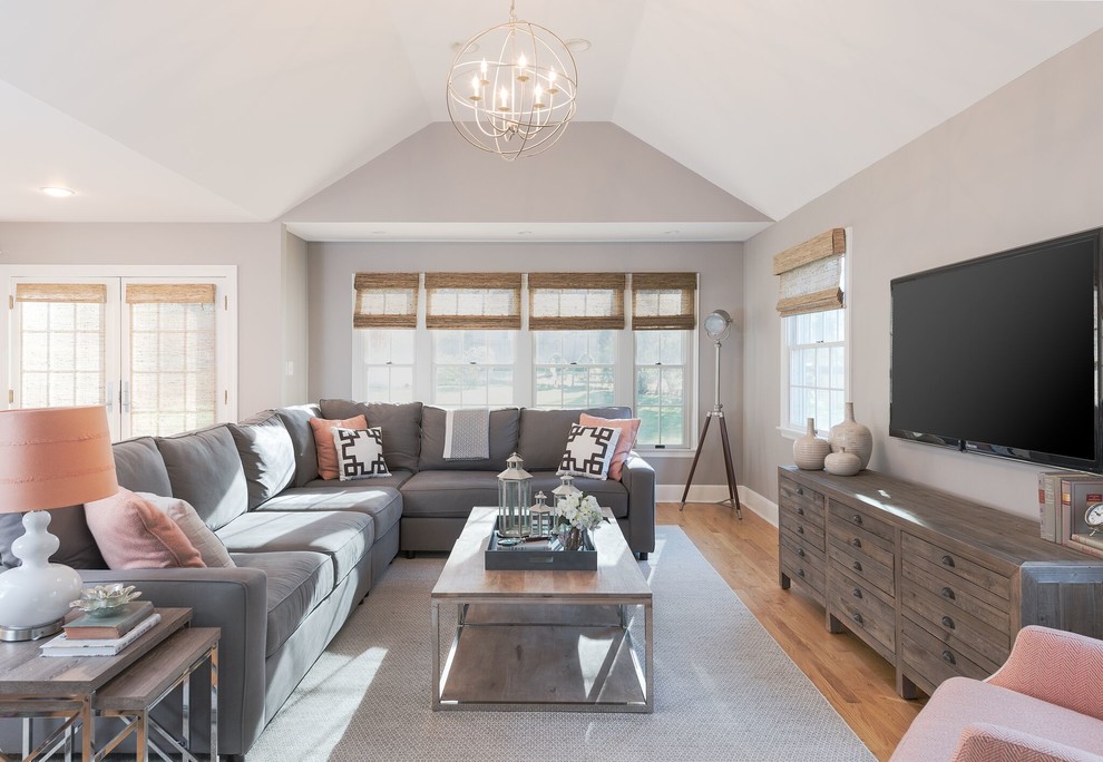 This is an example of a mid-sized transitional open concept family room in New York with grey walls, no fireplace, a wall-mounted tv and light hardwood floors.