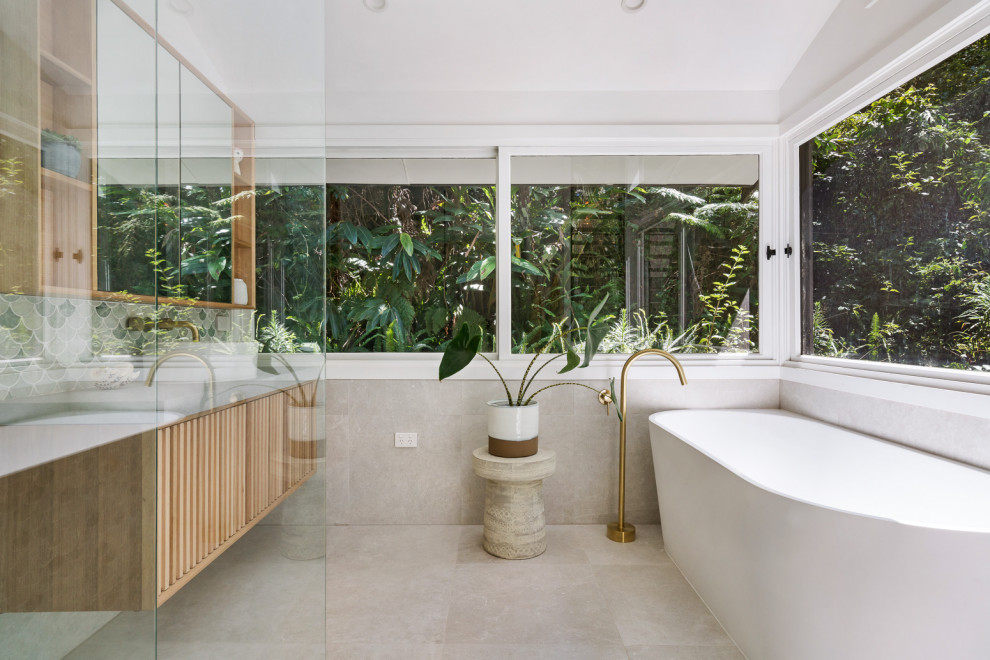 Inspiration for a contemporary bathroom in Sydney with flat-panel cabinets, medium wood cabinets, a freestanding tub, gray tile, grey walls, grey floor and a floating vanity.