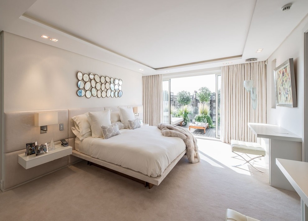 Photo of a mid-sized contemporary master bedroom in London with beige walls, carpet and beige floor.